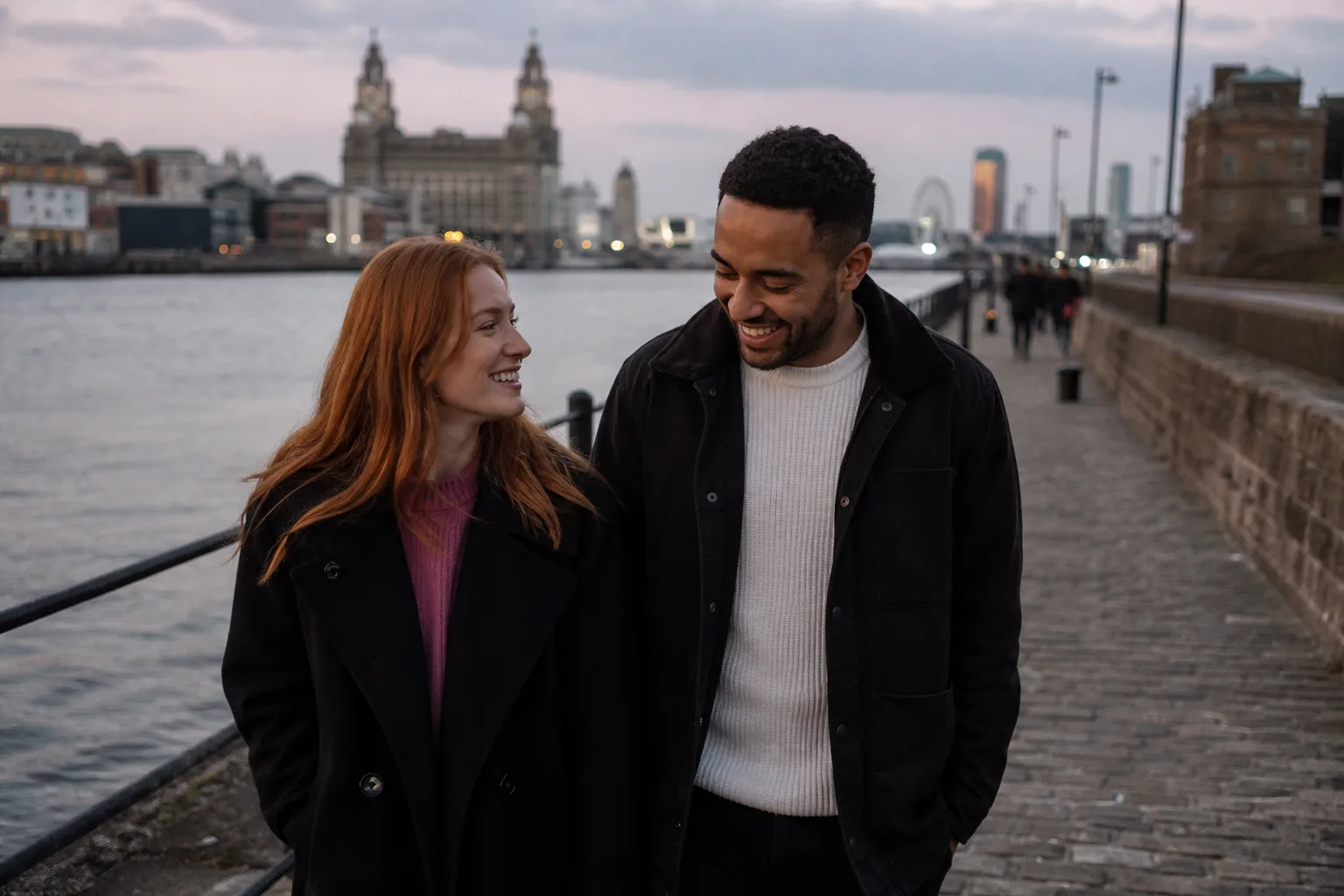 Two people talking over coffee beside Liverpool waterfront